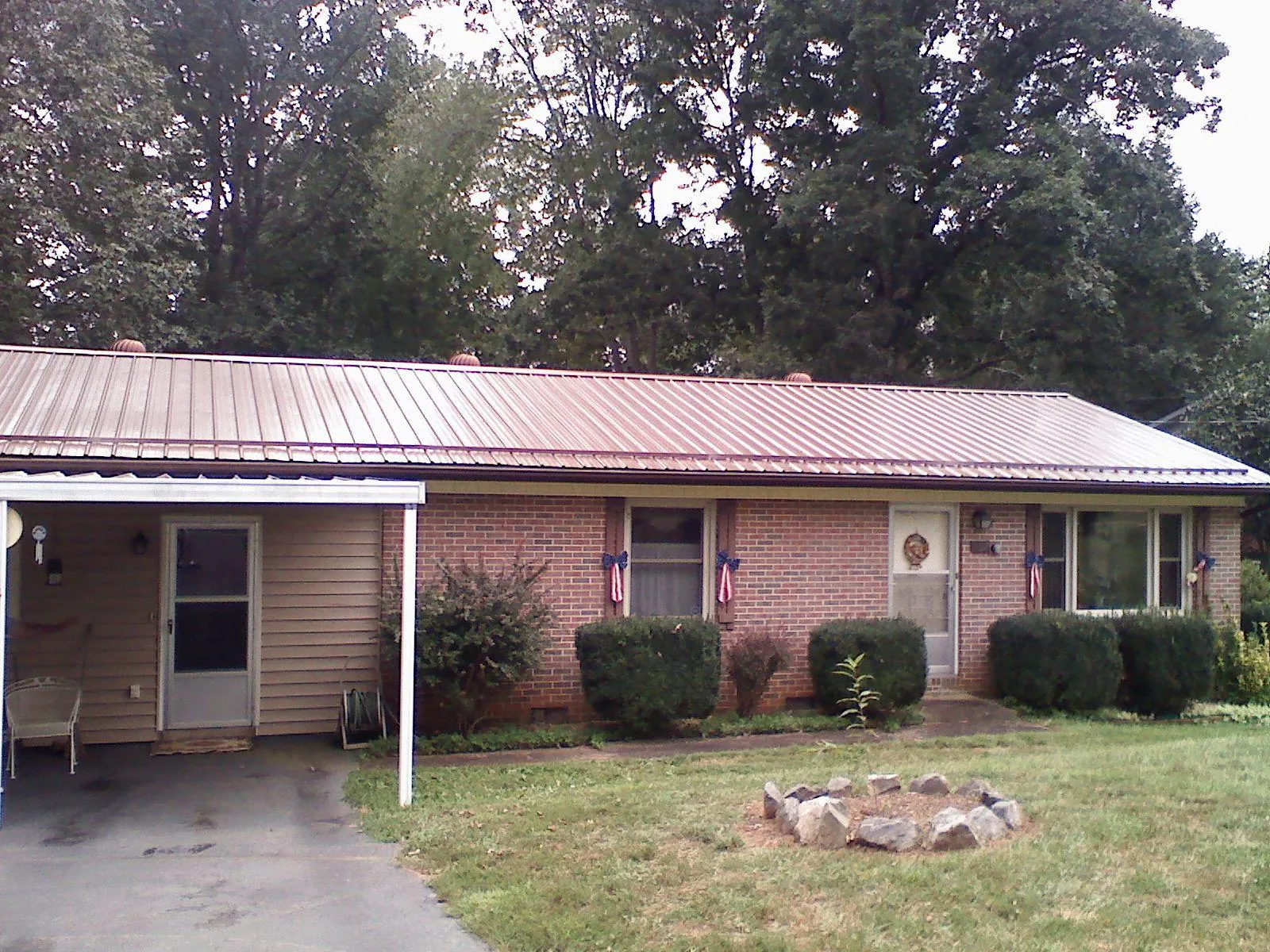 Bronze metal roof and carport on a brick ranch home — Roof Repair work by our crew in Fort Hill