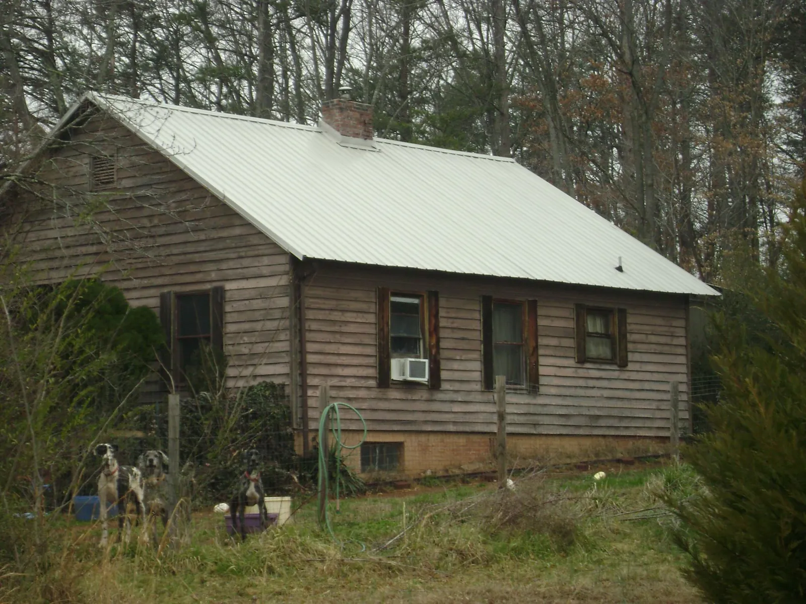 White metal roof on an old wood sided farmhouse, from a Metal Roof Installation job in Fort Hill